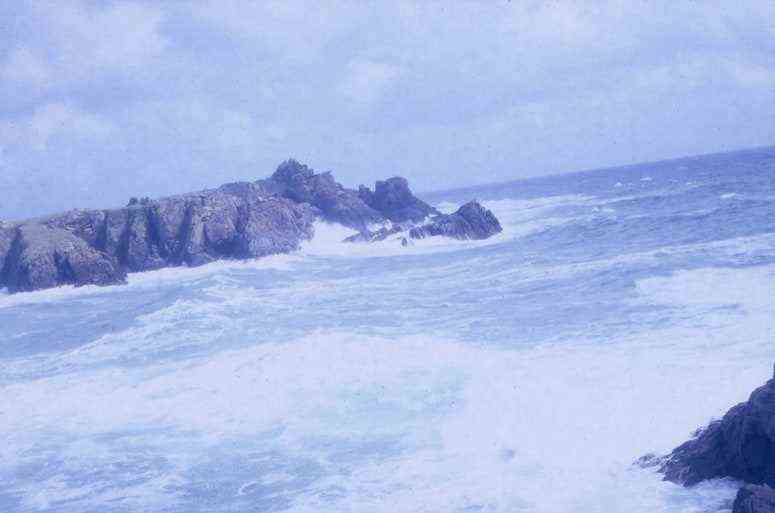 Ein Foto des Ozeans, der gegen eine Inselklippe stürzt