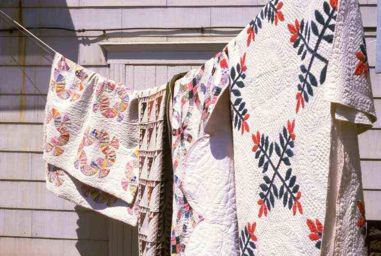 Ein Foto von Patchwork-Steppdecken, die an einer sonnigen Wäscheleine hängen