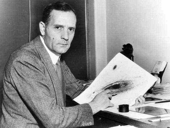 black and white image of Edwin Hubble sitting at a desk