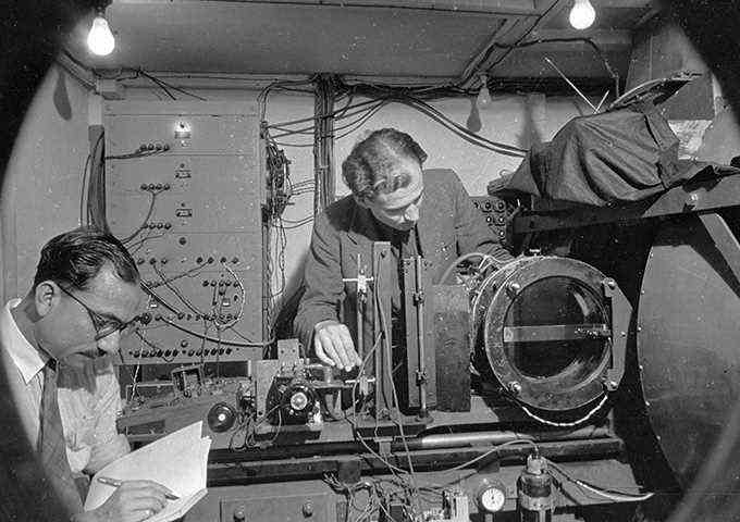 Schwarz-Weiß-Bild von Clifford Butler und einem anderen Wissenschaftler, der in einem Labor arbeitet