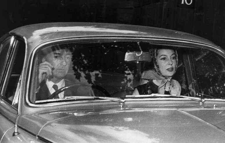 Schwarz-Weiß-Foto eines Mannes und einer Frau, die in einem Auto sitzen.