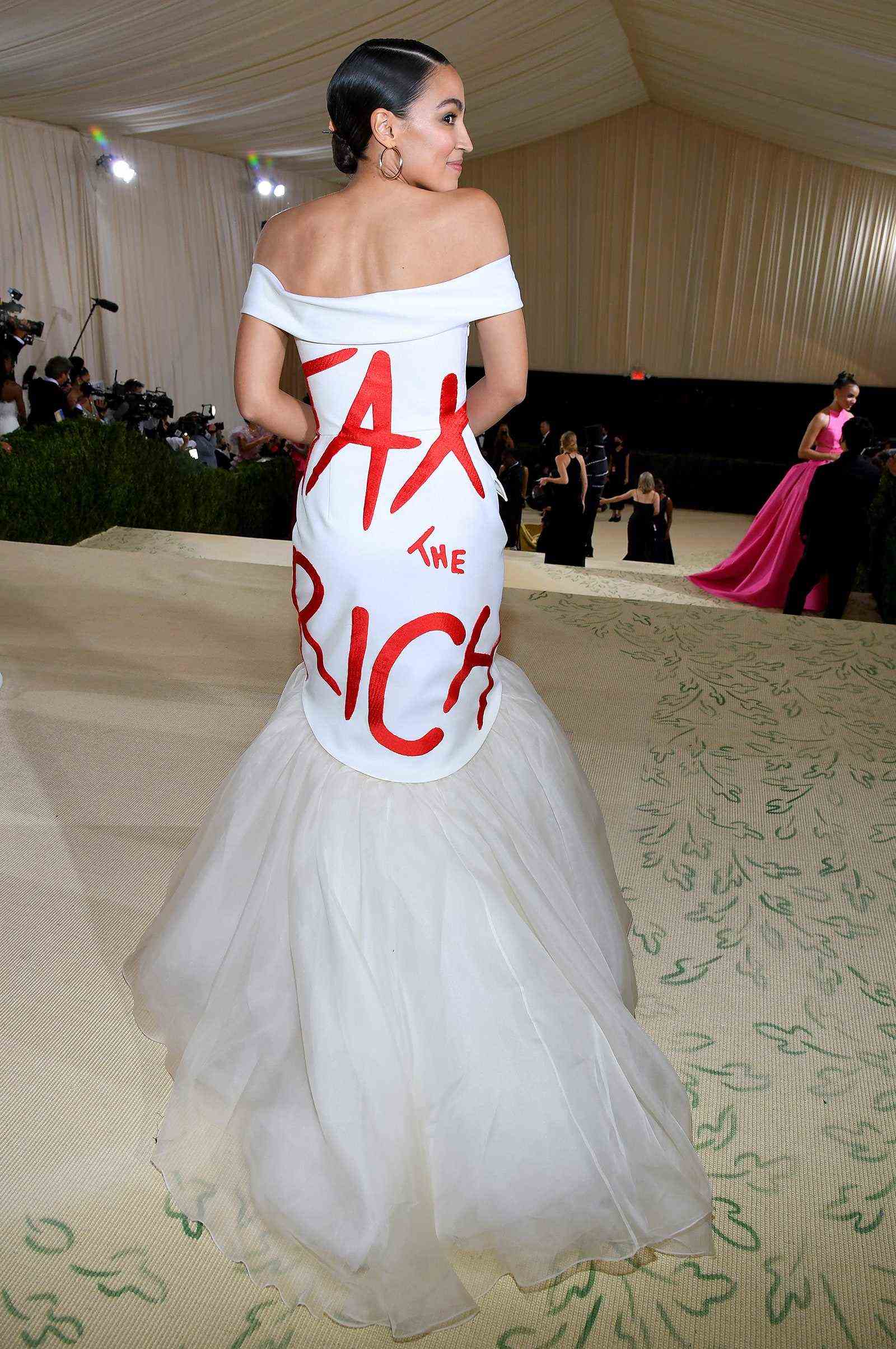 Alexandria OcasioCortez nimmt an der Met Gala 2021 in einem weißen Kleid teil, auf dem auf der Rückseite 