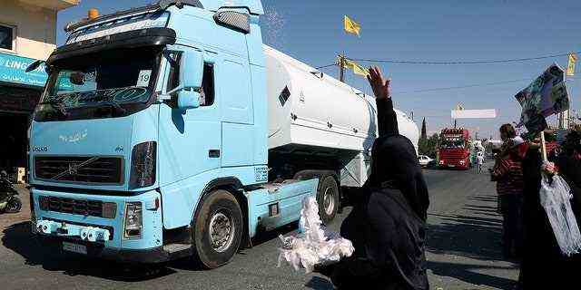 Ein Hisbollah-Anhänger wirft Reis über einen Konvoi von Tanklastwagen mit iranischem Diesel, der die Grenze von Syrien in den Libanon überquerte und am Donnerstag, 16. September 2021, in der östlichen Stadt el-Ain im Libanon ankommt. 
