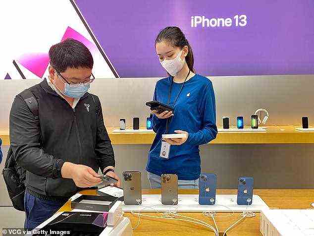 An Apple staff member talks with customer at the Apple store in The Mixc mall as iPhone 13, iPhone 13 Pro, new iPad and iPad mini go on sale