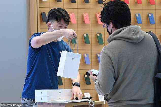 Jun Matsuda receiving his new Apple products from an Apple staff member inside the Apple Store on George Street on September 24, 2021 in Sydney, Australia