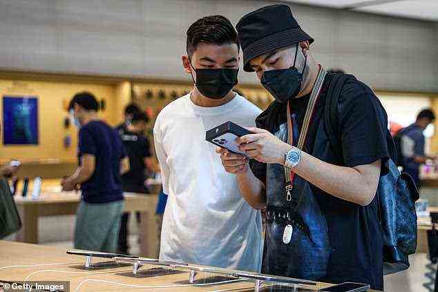 Haikal Putra (R) and Wayne Chang look at the iPhone box at the Apple Store in Orchard Road in Singapore