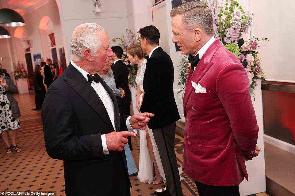 A jolly good chat: Daniel was photographed conversing with Prince Charles as Bond stars chatted with royal family members
