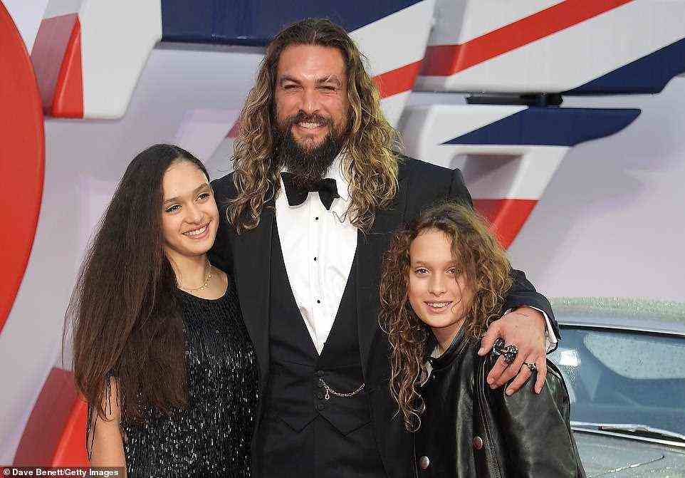 Family man: Aquaman's Jason Momoa cut a dapper figure when he arrived ahead of the film's screening and posed for photographers alongside his daughter