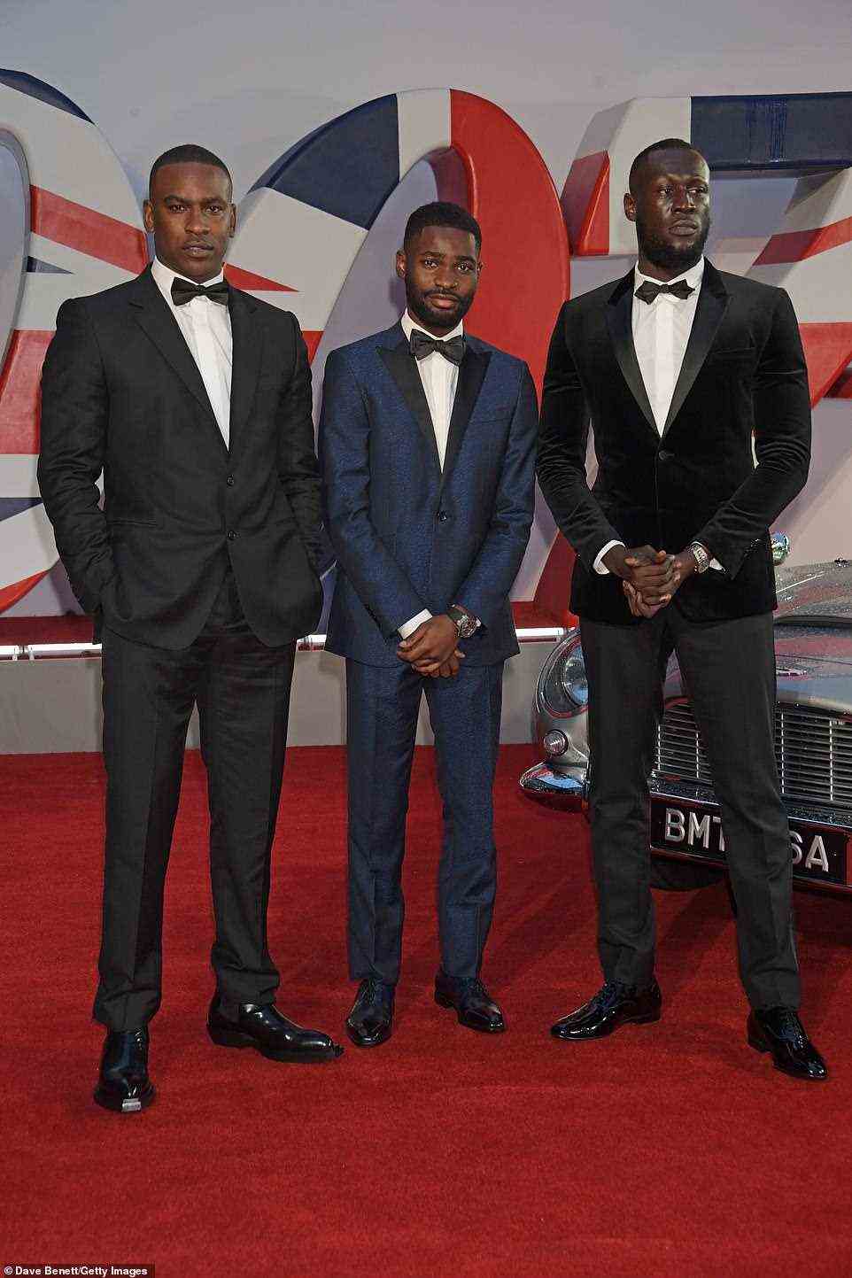 Looking good: Rappers Skepta, Dave and Stormzy posed together on the carpet and all looked equally suave in smartly tailored suits