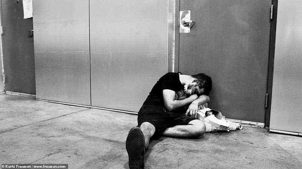 Mittellos: Ein Mann war zusammengesunken und schlief auf einer Pappschachtel, während er ausgestreckt auf dem Bürgersteig lag