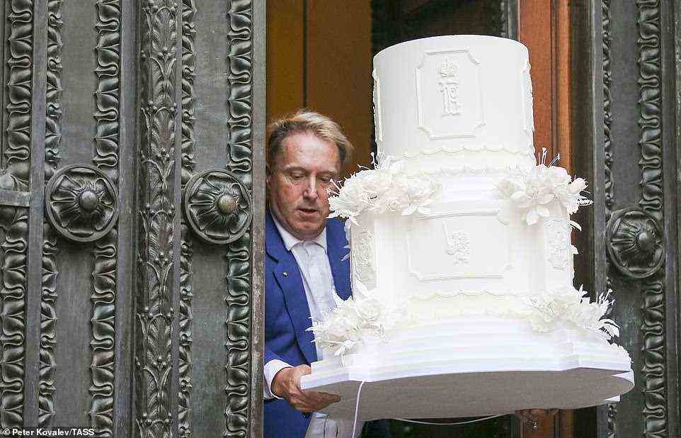 A cake mockup is delivered at the Russian Museum of Ethnography for a reception marking the wedding of Grand Duke George Mikhailovich of Russia, a descendant of the Romanov dynasty, and Rebecca (Victoria) Bettarini of Italy