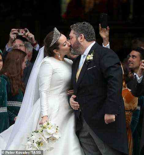 The newlyweds shared a kiss as they walked down the steps of St Isaac's Cathedral in the city after the ceremony today