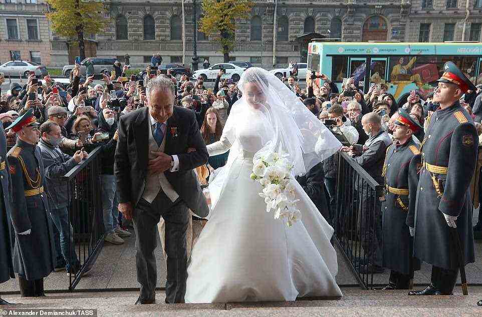 Crowds gathered outside the venue to wish the bride well as she arrived at the event with her father  Roberto (pictured)