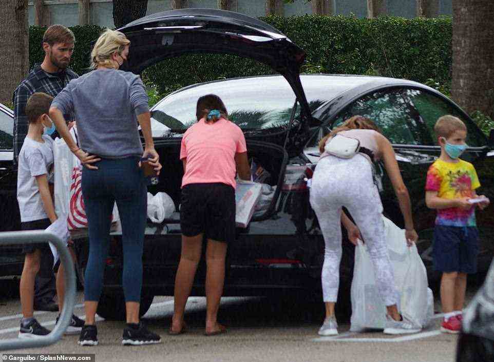 Ivanka is pictured loading bags up to the trunk of the car in the parking lot