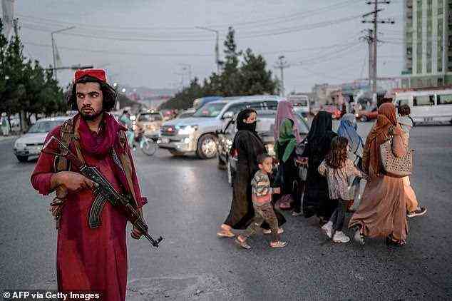 On Tuesday, a further nail was driven into the coffin of Afghan female rights as the Taliban announced that women would not be allowed to attend classes or work at Kabul University ‘until an Islamic environment is created'. Pictured: A Taliban fighter stands guard along a road in Kabul on September 30, 2021