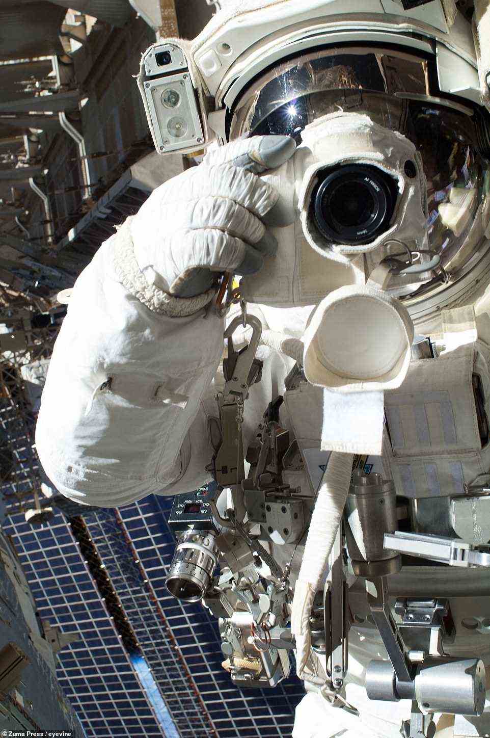 Chris Cassidy von der NASA macht am 16. Juli 2013 ein Selfie mit einer Digitalkamera, bevor sein Weltraumspaziergang nach kaum mehr als einer Stunde abgebrochen wurde.  Sein Astronaut-Kollege Luca Parmitano (der sich außerhalb des Rahmens befindet) hatte gemeldet, dass Wasser hinter seinem Kopf in seinem Helm schwamm.  Obwohl das Wasser kein unmittelbares Risiko darstellte, entschied sich Mission Control, die EVA vorzeitig zu beenden.