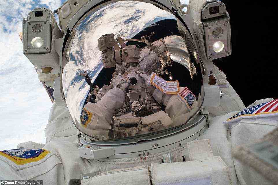 Mark Vande Hei, hier mit heruntergeklapptem Visier, fängt die Erde und die ISS in einem weiteren Selfie ein, das am 23. Januar 2018 aufgenommen wurde.