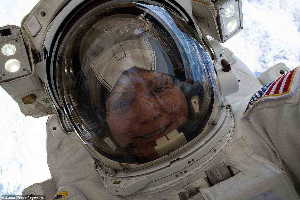 Anne McClain von der NASA schwebt breit grinsend mit hochgezogenem Visier während einer Exkursion zur Aufrüstung der Energiespeicherkapazität der ISS am 22. März 2019 260 Meilen über der Erdoberfläche. Dies war McClains erster Weltraumspaziergang.