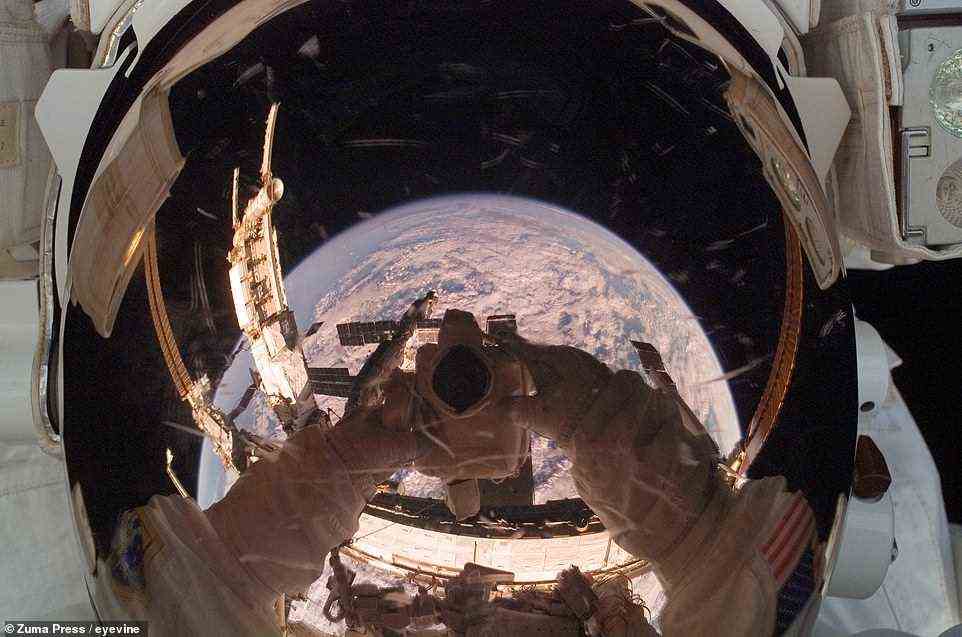 Während der 59. ISS-Exkursion am 14. Juni 2018 fängt Nick Hague von der NASA die Reflexion der Erde in seinem Visier von einer der backbordseitigen Stützstrukturen der Raumstation ein.