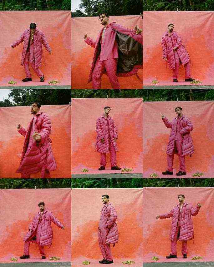 Ein Kontaktbogen mit neun Porträts des Rappers Bad Bunny, der vor einem orangefarbenen Hintergrund für die Kamera tanzt.  Er trägt einen pinkfarbenen Daunenmantel, eine passende Daunenhose, ein pinkfarbenes Hemd mit Knöpfen und klobige dunkle Anzugschuhe. 