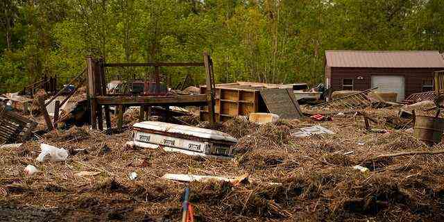 Ein verdrängter Sarg, der während der Überschwemmungen durch den Hurrikan Ida von einem Friedhof geschwommen ist, befindet sich am 27. September in Ironton, Louisiana, zwischen verdrängtem Sumpfgras und Ruinen.