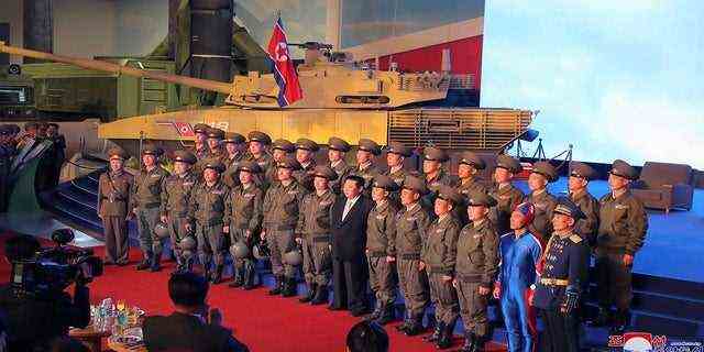 Nordkoreas Machthaber Kim Jong Un (Mitte) posiert für ein Gruppenfoto mit Kampfpiloten, die am Montag bei der Eröffnung einer Ausstellung von Waffensystemen in Pjöngjang, Nordkorea, den Demonstrationsflug gemacht haben.  (Koreanische Zentrale Nachrichtenagentur/Korea News Service über AP)