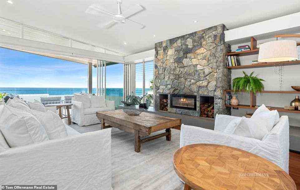 Das offene Wohnzimmer bietet ein luxuriöses Design mit einer Küche mit Strandblick, mehreren Essbereichen und einer raffinierten Lounge mit einem holzbefeuerten Kamin aus Steinmauerwerk
