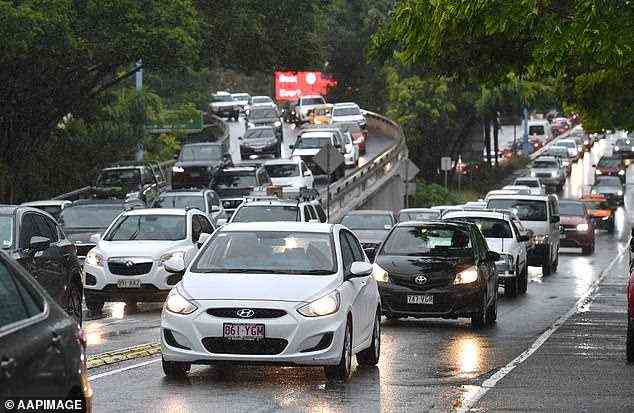 Der Verkehr zur Hauptverkehrszeit kriecht durch Brisbane, während starker Regen die Straßen verwüstet