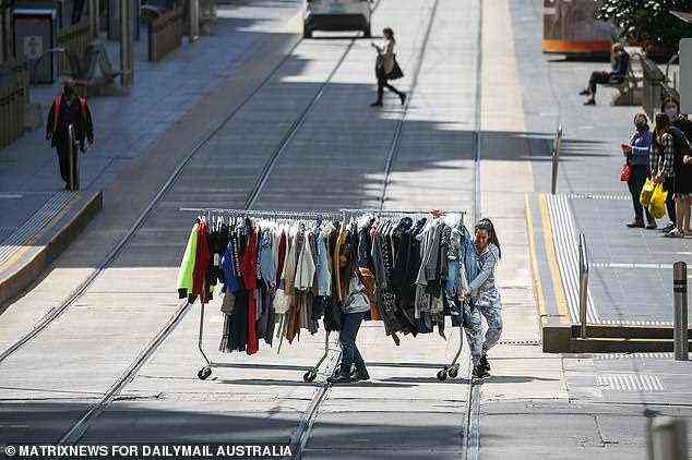 Melbourne ist so leer, dass Ladenangestellte, die Kleiderständer transportieren, kein Problem damit haben, die leeren Straßen zu überqueren (Bild am Donnerstag).