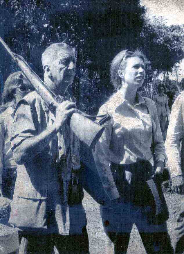Prinzessin Anne, bewacht von Senior Hunter Colonel Eric Hayes-Newington, geht durch den Busch zum Treetops Hotel in Kenia.  Es war eine sentimentale Reise für die Prinzessin im Februar 1952