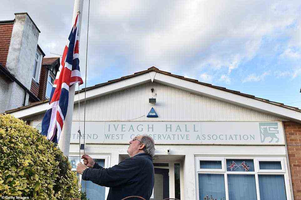 A member of the Southend West Conservative Association lowers the Union Jack Flag to half mast outside Iveagh Hall, the Constituency office address, following the stabbing of UK Conservative MP Sir David Amess
