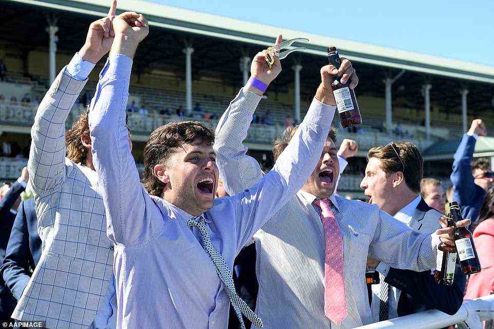 A group of mates cheer as they watch the horses take to the track at The Tab Everest