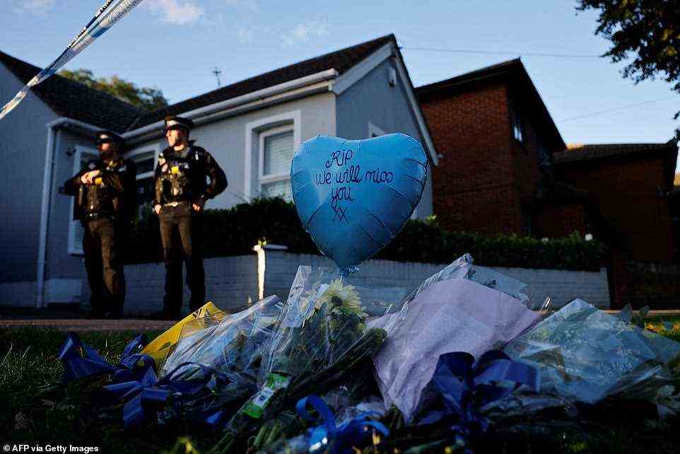 Floral tributes are placed near the scene of a fatal stabbing as police officers stand guard near the Belfairs Methodist Church