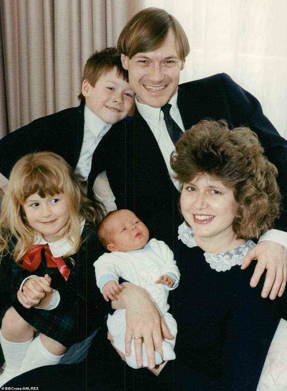 Family man: David beams proudly with his son, also David, and daughter Katie while wife Julia cradles baby Alexandra in 1990