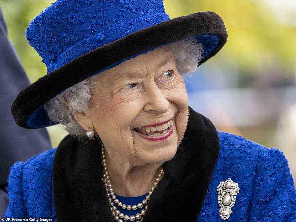 Beaming: The Queen's button-up coat boasted a black collar and wrist-detailing, while her sophisticated head piece matched the design by featuring a black rim