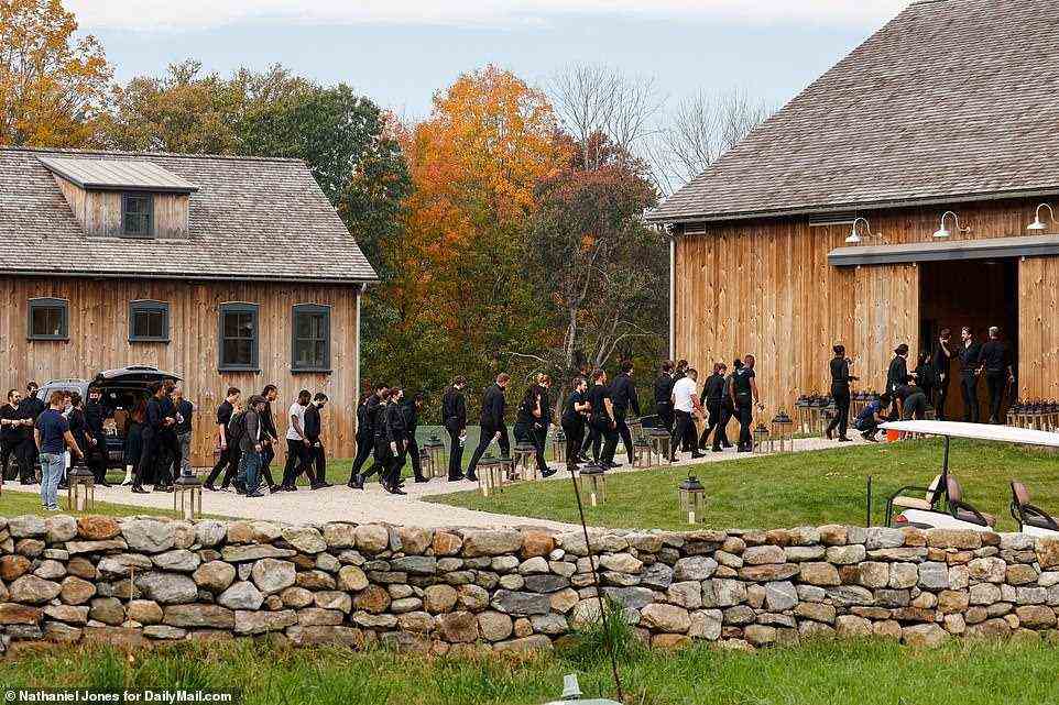 Wedding staff line up in all black, wearing black face masks, and enter the wedding venue Friday. Preparations are swiftly underway and appear far from done on the morning of Jennifer Gates' and Nayel Nassar's official wedding day