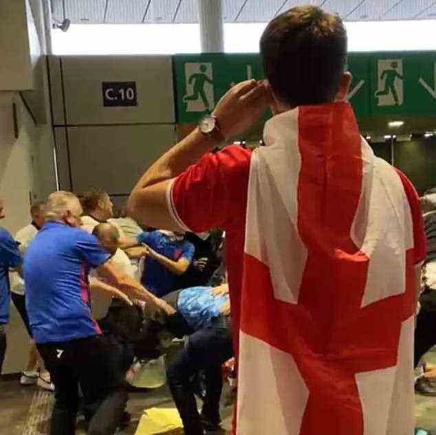 Entsetzt zusehen: Ein Fan mit einer englischen Flagge sieht zu, wie Fans mit Tickets mit den Eindringlingen prügeln