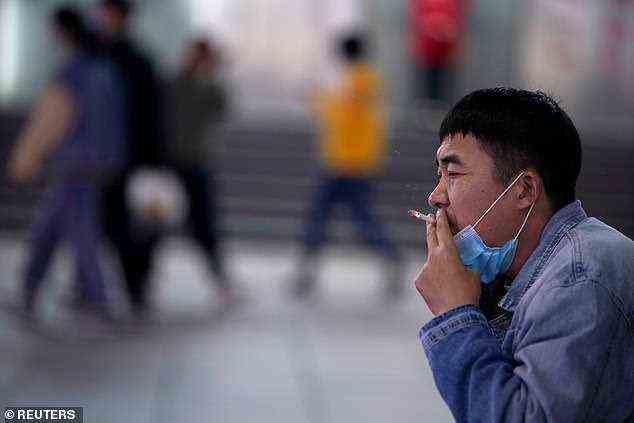 Rauchen kann mit Stress und anderen psychischen Auswirkungen der Pandemie in Verbindung gebracht werden.  Im Bild: Ein Mann raucht auf der Straße in Shanghai, China, Oktober 2020