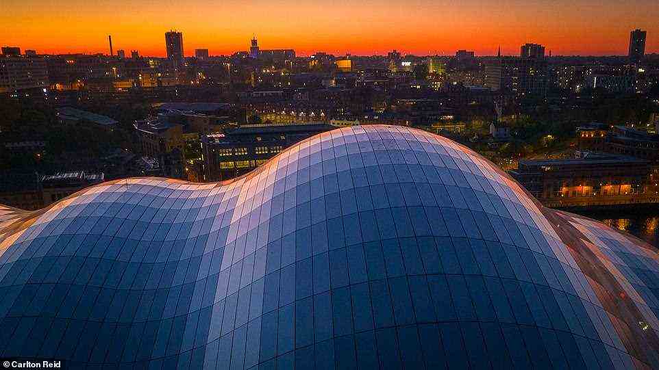 The bike ride saw Carlton set off from Newcastle's Quayside. From there, he rolled over the Millennium Bridge beneath the 'futuristic curves' of the Sage Gateshead cultural centre, pictured above at sunset