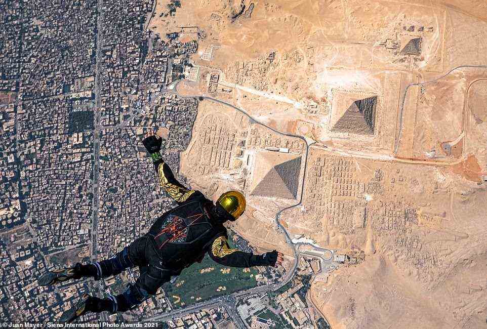 This amazing picture was shortlisted in the Sports In Action category. The photographer, Juan Mayer, said: 'I took this photo of this skydiver freefalling over the Pyramids while I was also freefalling following him. He is a professional skydiver, but it was his first time skydiving over the Pyramids. We jumped from 15,000ft and I took this photo at about 10,000ft. It's also a highlight that the skydiver on this photo is paraplegic, so ground staff were waiting for him with his wheelchair just a few metres from one of the pyramids, where we landed'