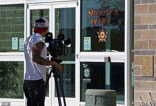 Ein Nachrichtenkameramann zeichnet am Freitag den Eingang des Sheriff-Büros des Santa Fe County in Santa Fe auf.  Schauspieler Alec Baldwin feuerte am Set eines Westerns, der auf der Bonanza Creek Film Ranch gedreht wurde, eine Requisitenpistole ab und tötete den Kameramann, sagten Beamte