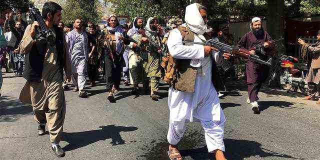 Taliban-Soldaten gehen am Dienstag, 7. September 2021, in der Nähe der pakistanischen Botschaft in Kabul, Afghanistan, auf Afghanen zu und rufen Parolen. (AP Photo/Wali Sabawoon)