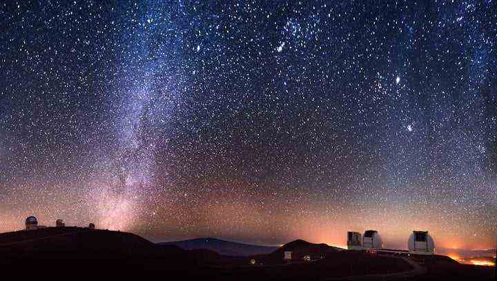Der Gipfel des Maunakea, Hawai'i bei Nacht, mit den beiden Keck-Teleskopkuppeln vorne rechts.