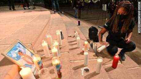 Die Schauspielerin Sarah Wilkinson zündet eine Kerze an, die während einer Mahnwache zu ihrer Ehrung am 23. Oktober 2021 im Albuquerque Civic Plaza in Albuquerque, New Mexico, um ein Foto der Kamerafrau Halyna Hutchins herum platziert wurde. 