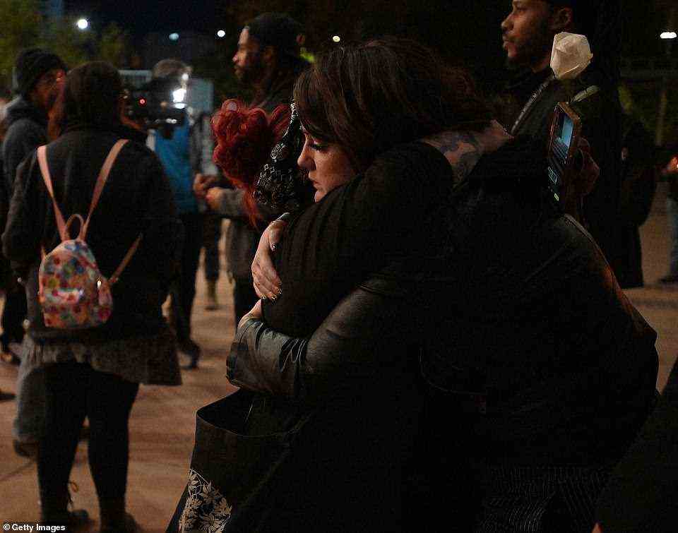 Two people comfort each other during a vigil held to honor cinematographer Halyna Hutchins at Albuquerque Civic Plaza