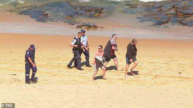 Die Tragödie entfaltete sich vor schockierten Strandbesuchern (im Bild im Gespräch mit der Polizei)