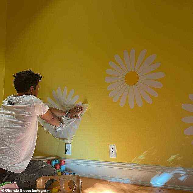 Hart bei der Arbeit: Ein weiterer Schnappschuss sah, wie der zweifache Vater Orlando niedlich Gänseblümchen an die Wand des leuchtend gelben Kinderzimmers seiner Tochter malte