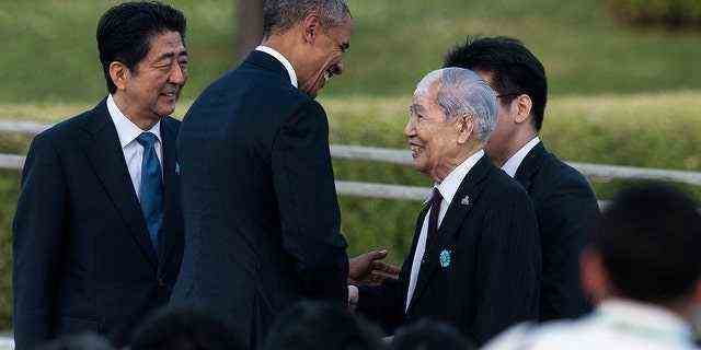 US-Präsident Obama (zweiter von links) schüttelt Sunao Tsuboi, einem Überlebenden des Atombombenabwurfs von Hiroshima, die Hand, als der japanische Premierminister Shinzo Abe (links) im Mai 2016 das Ehrenmal im Hiroshima Peace Memorial Park in Hiroshima betrachtet.