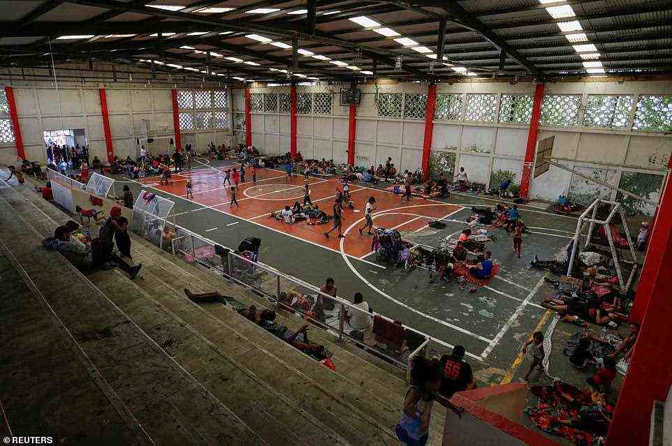 Migrants rest in a sports court in Villa Comaltitlán as they take part in a caravan heading to Mexico City