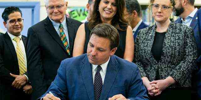 Der Gouverneur von Florida, Ron DeSantis, Mitte, unterzeichnet am Dienstag, den 4. Mai 2021, in der West Miami Middle School in Miami Gesetze zur Überarbeitung von Floridas Alphabetisierung und frühkindlichem Lernen.